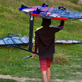 Mario Kümpel Syrferzyzz carrying wivndsurf board and foil in windsurf clothing